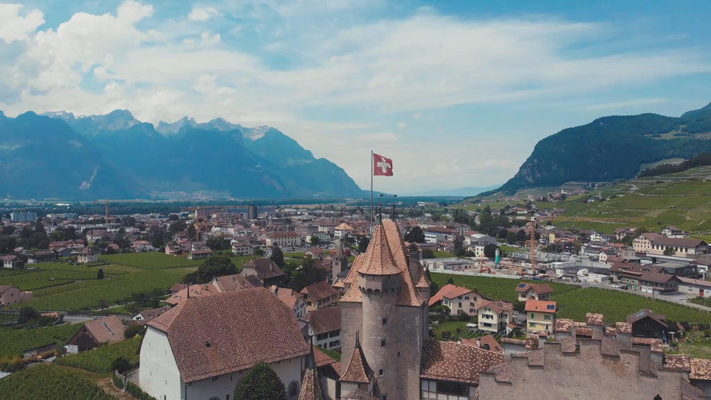 Idilic Swiss town with view of the lake and mountains, focused Swiss flag on top of the old town building